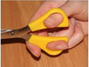 hand holding yellow handles scissors with their thumb and middle finger, using their index finger to guide where they cut